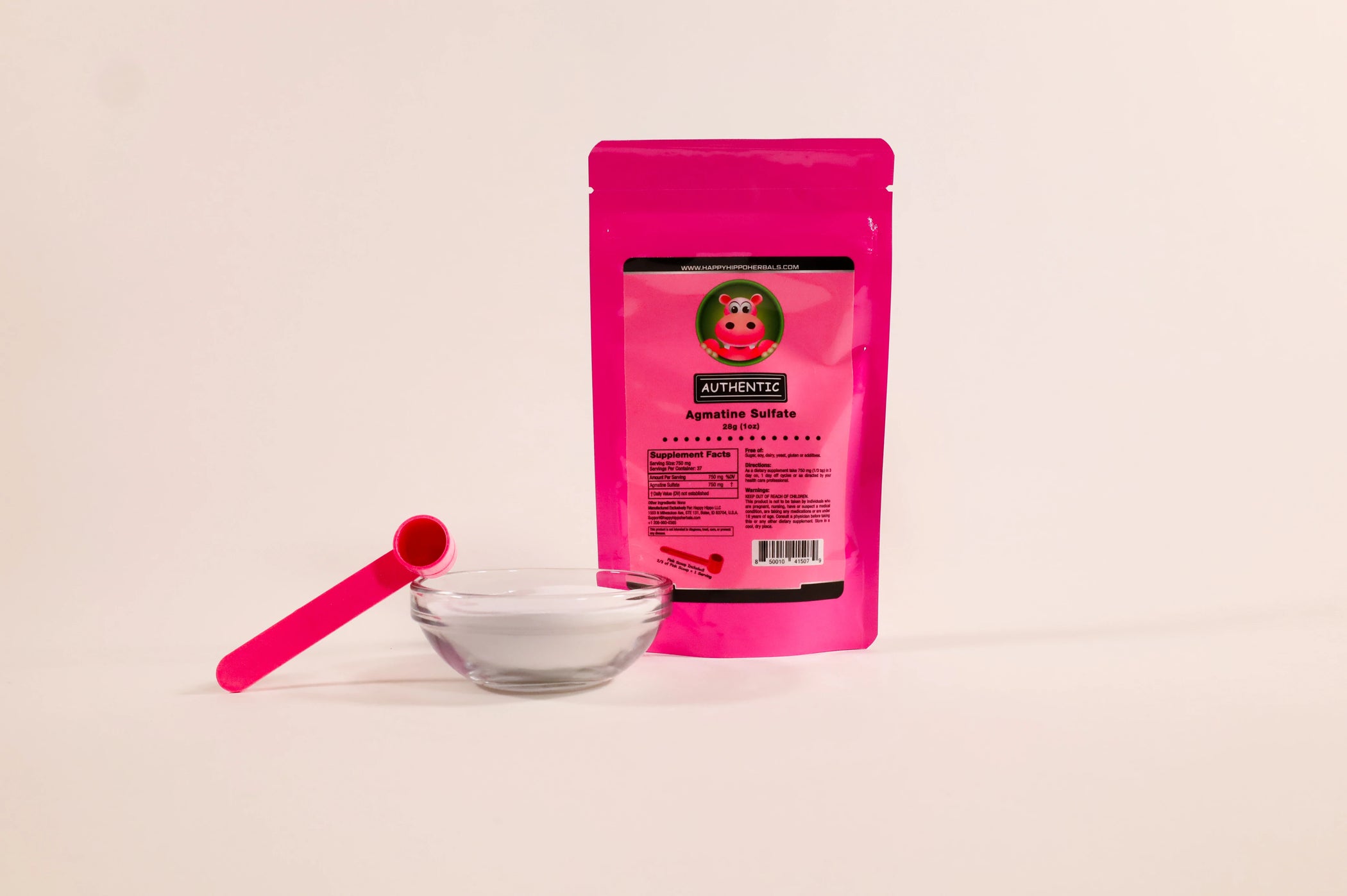 Product image depicting a 1 ounce packet of Happy Hippo Herbals brand Agmatine Sulfate next to a glass bowl of loose agmatine sulfate powder and a 1 gram little pink measuring scoop