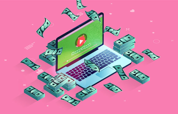 Featured image depicting an open laptop computer surrounded by stacks of money, against a pink background.