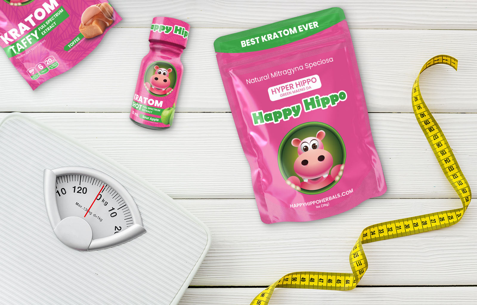 Featured image depicting a a 1oz packet of happy hippo brand, Green Maeng Da Kratom Powder. Surrounding the packet are a weight scale, a soft measuring tape, and a bottle of Full Spectrum Kratom Etract, Sour Apple Flavor Kratom Shot