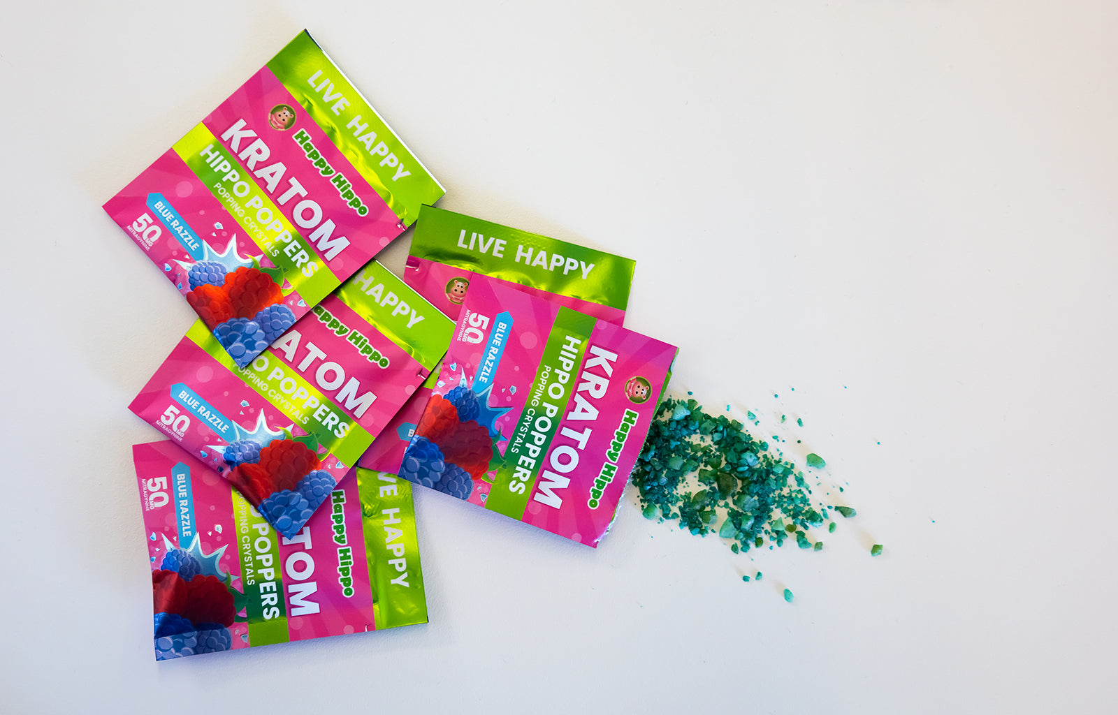 Featured Image depicting several packets of Hippo Poppers - Popping Candy Crystals! One of the packets is open, with several green popping candy crystals spilled out onto the counter.