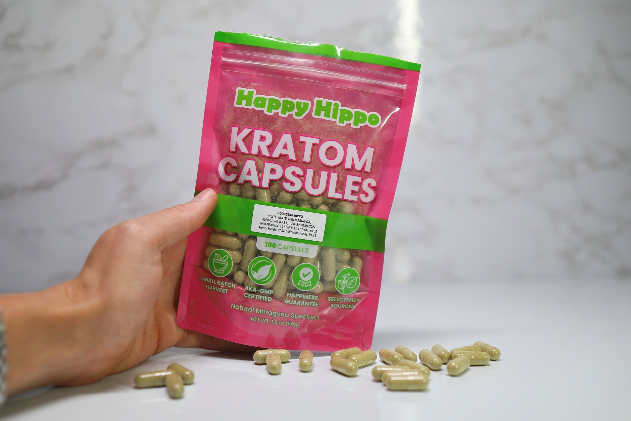 Hand-holding-Kratom-capsule-bag-white-background