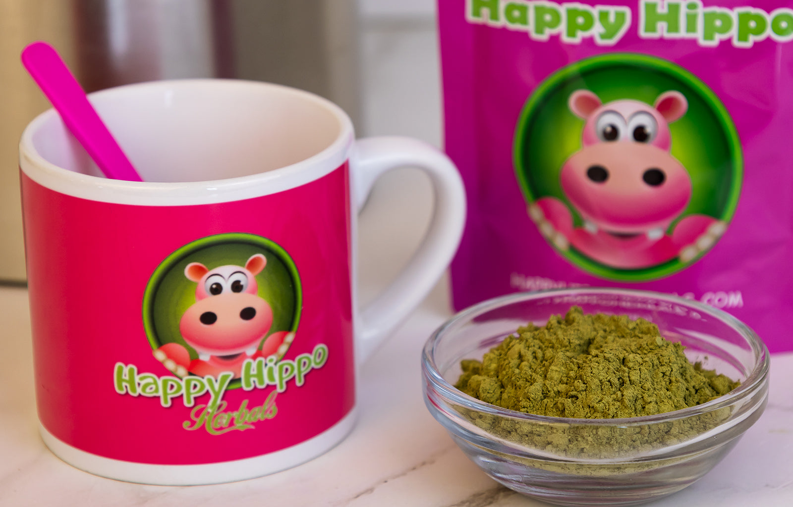Featured image depicting an assortment of Happy Hippo branded products, a coffee mug, a 1oz packet of White Maeng Da Kratom Powder, and a small ramekin filled with loose white maeng da kratom powder.