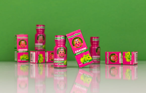 Featured image depicting a variety of Kratom Extract Shots, K Shots, Liquid Kratom Extract, and Kratom Energy Shots, on a reflective table top against a green background.