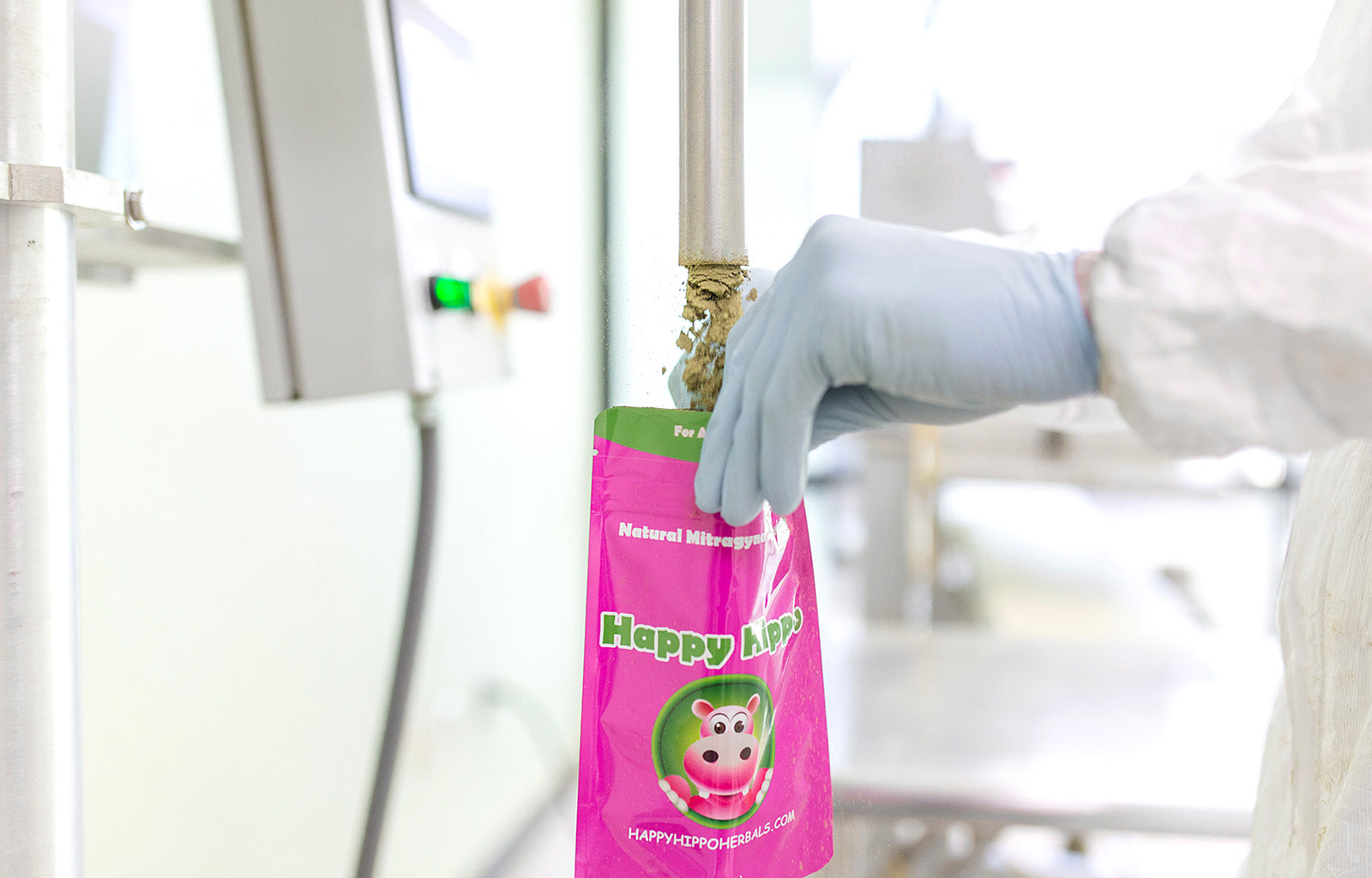Featured image of a Happy Hippo branded packet of Green Maeng Da kratom powder, being filled from a machine in a sterile lab-like environment.