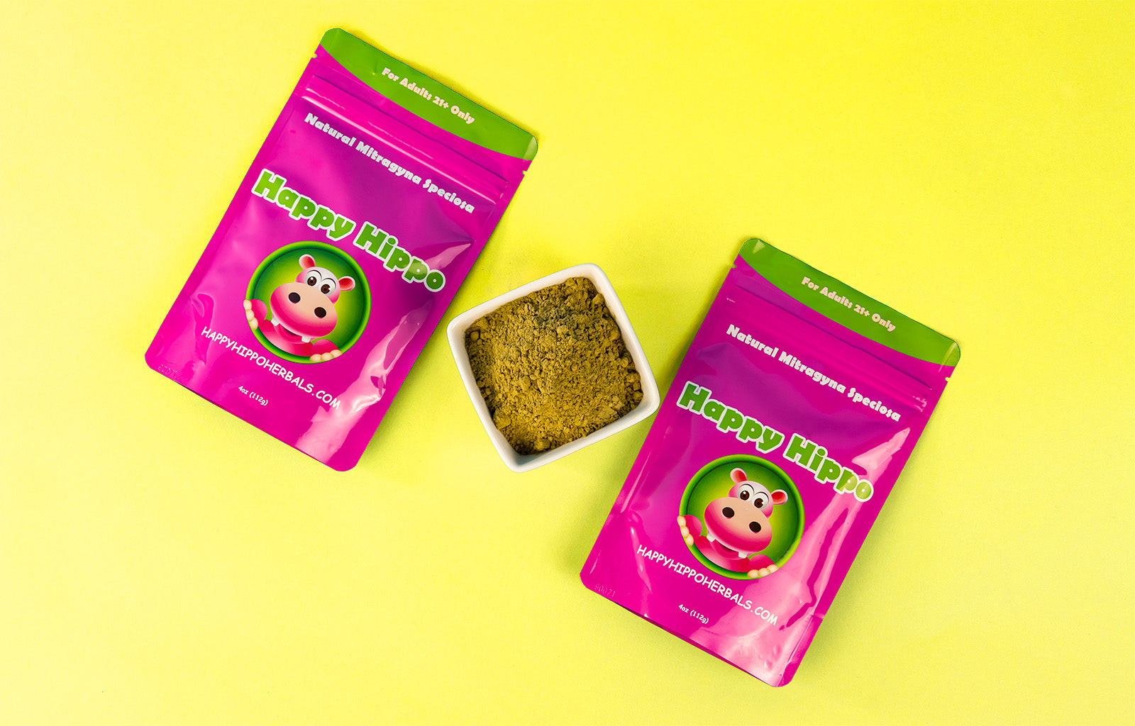 Featured Image depicting two 4oz packets of Happy Hippo brand Yellow Vein Kratom, in between which rests a square bowl filled with loose Yellow Vietnam Kratom Powder