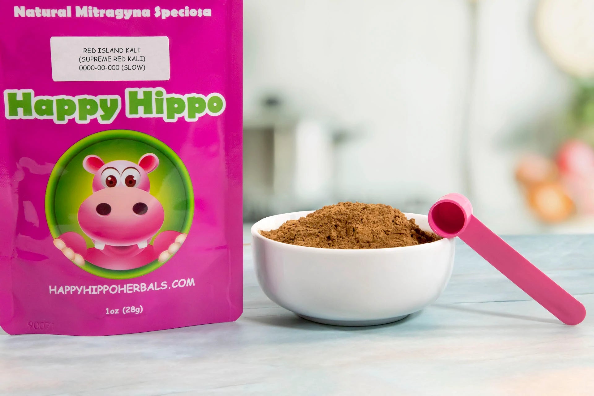 Product image depicting a Happy Hippo Herbals branded, 1oz packet of Red Island Kali Kratom Powder (Supreme Red Kali); Sitting next to the packet is a white bowl heaped with a mound of loose Red Island Kali Kratom Powder, and a 1gram little pink measuring scoop!